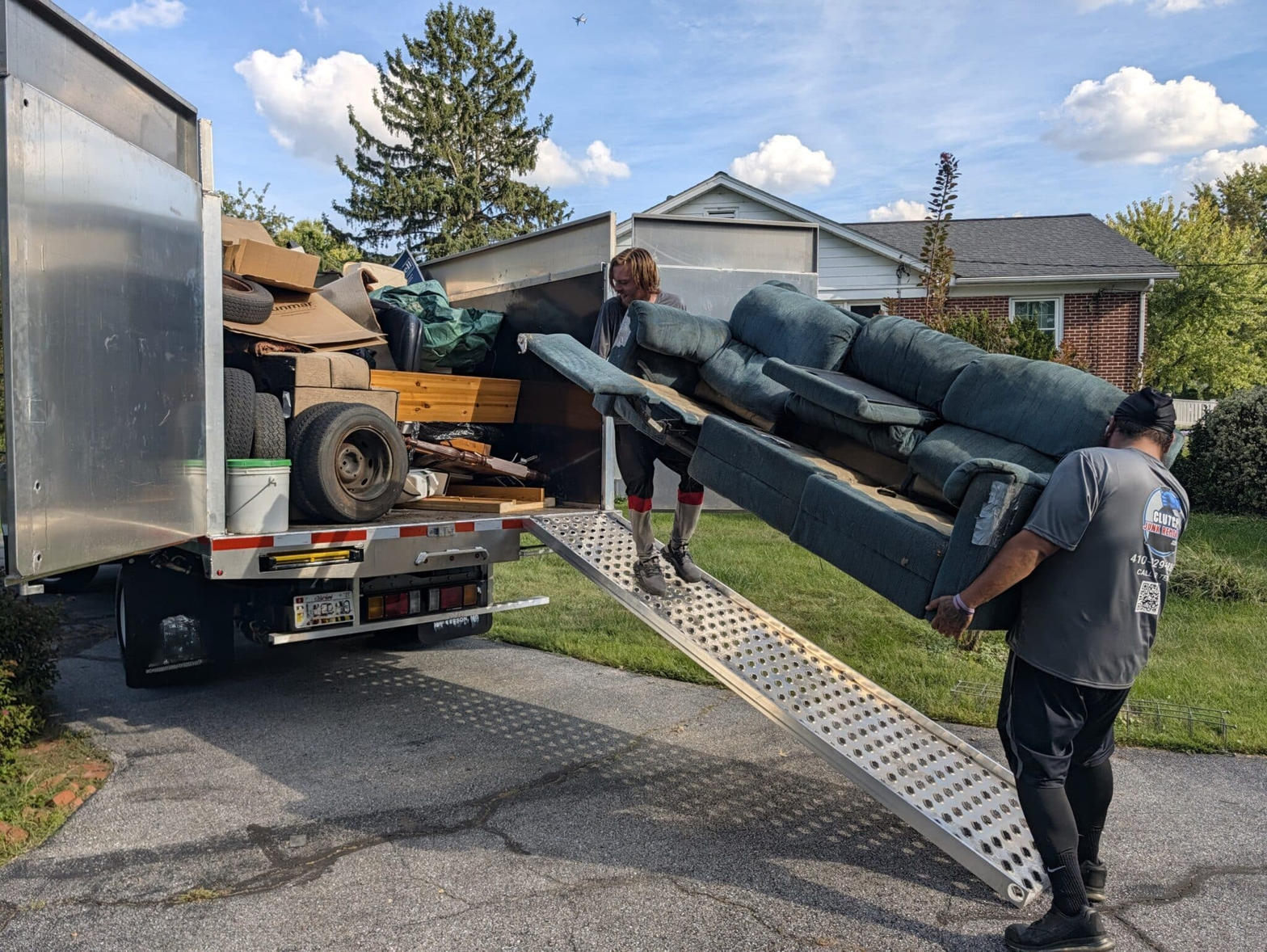 Loading sofa onto junk removal truck in Manor
